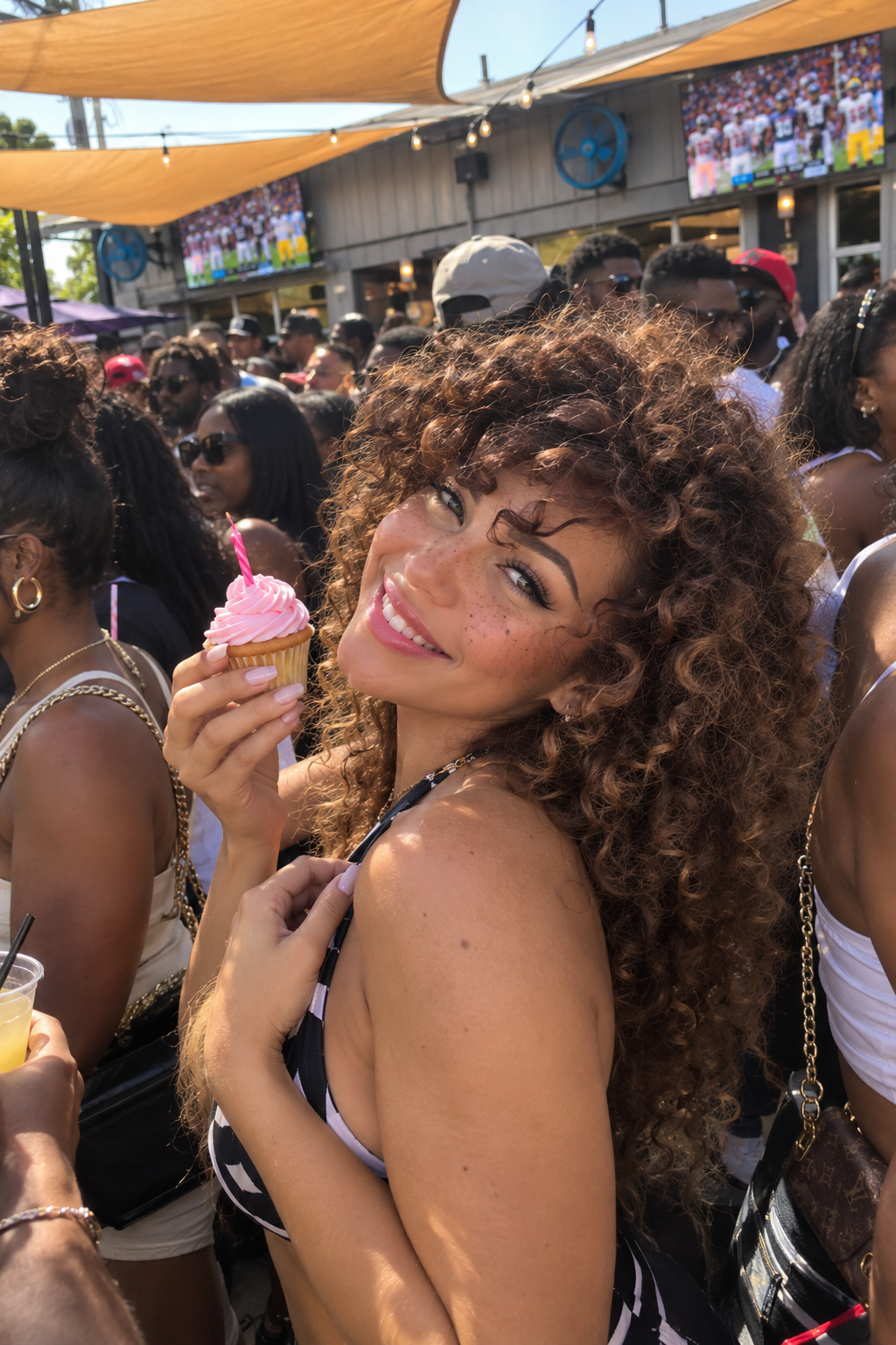 Birthday guest celebrating with a cupcake on the packed Chapman Sundays patio in EaDo, Houston