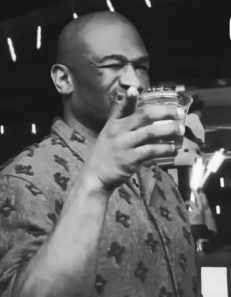 Black-and-white photograph of a guest raising a glass